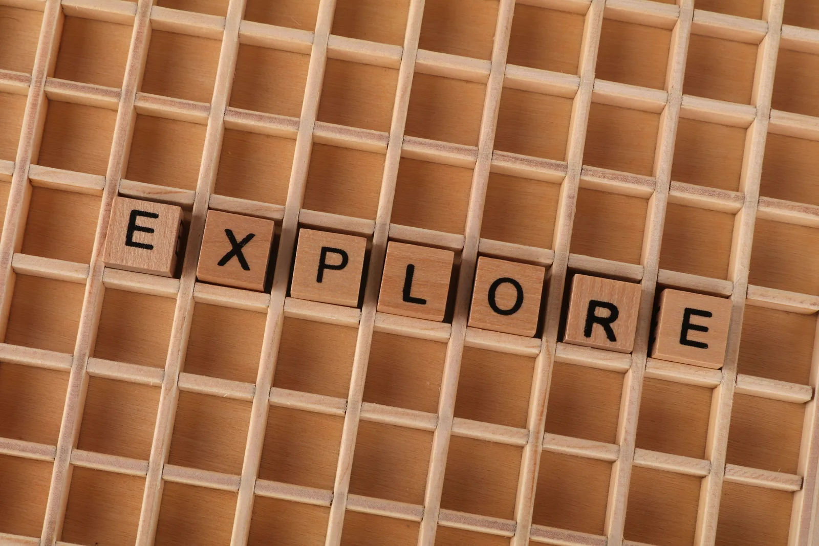 Wooden blocks spelling the word 'explore' on a wooden grid backdrop. 5 honest notes on MBTI explorers compatibility