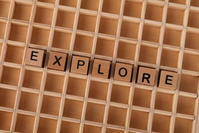 Wooden blocks spelling the word 'explore' on a wooden grid backdrop. 5 honest notes on MBTI explorers compatibility